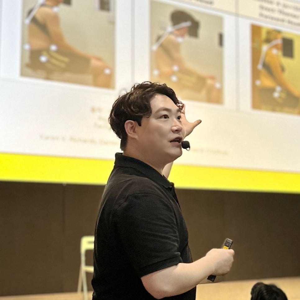 노란 슬라이드 앞에서 마이크를 차고 설명하는 물리치료사 김윤하